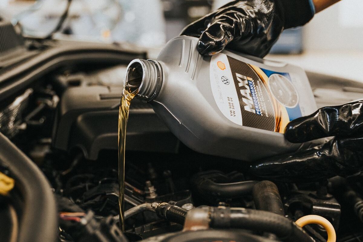 Mechanic pouring engine oil into a van engine