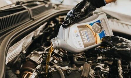 Mechanic pouring fresh engine oil into a diesel van engine to diagnose oil consumption