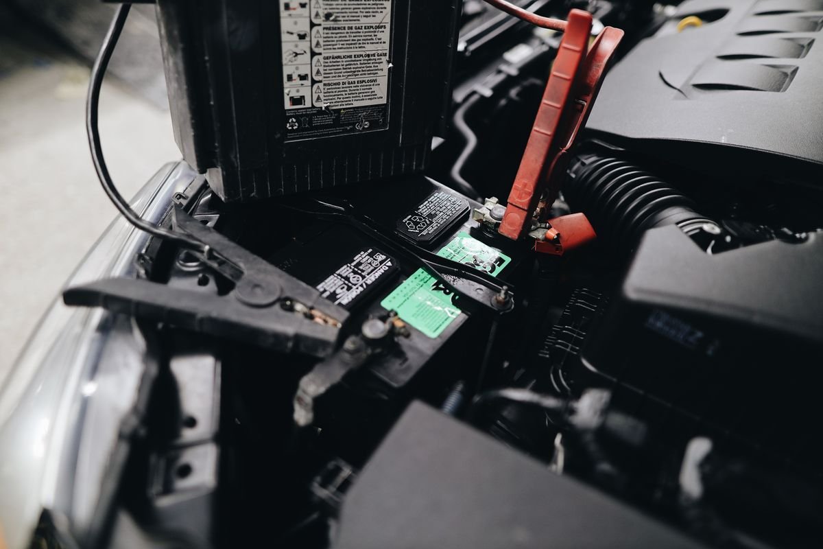 Car battery being jump-started with cables in the engine bay