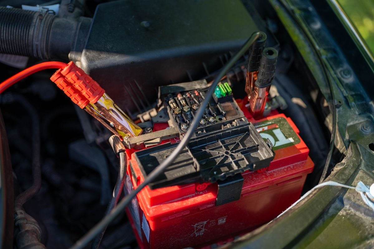 Car battery with red jumper cables connected