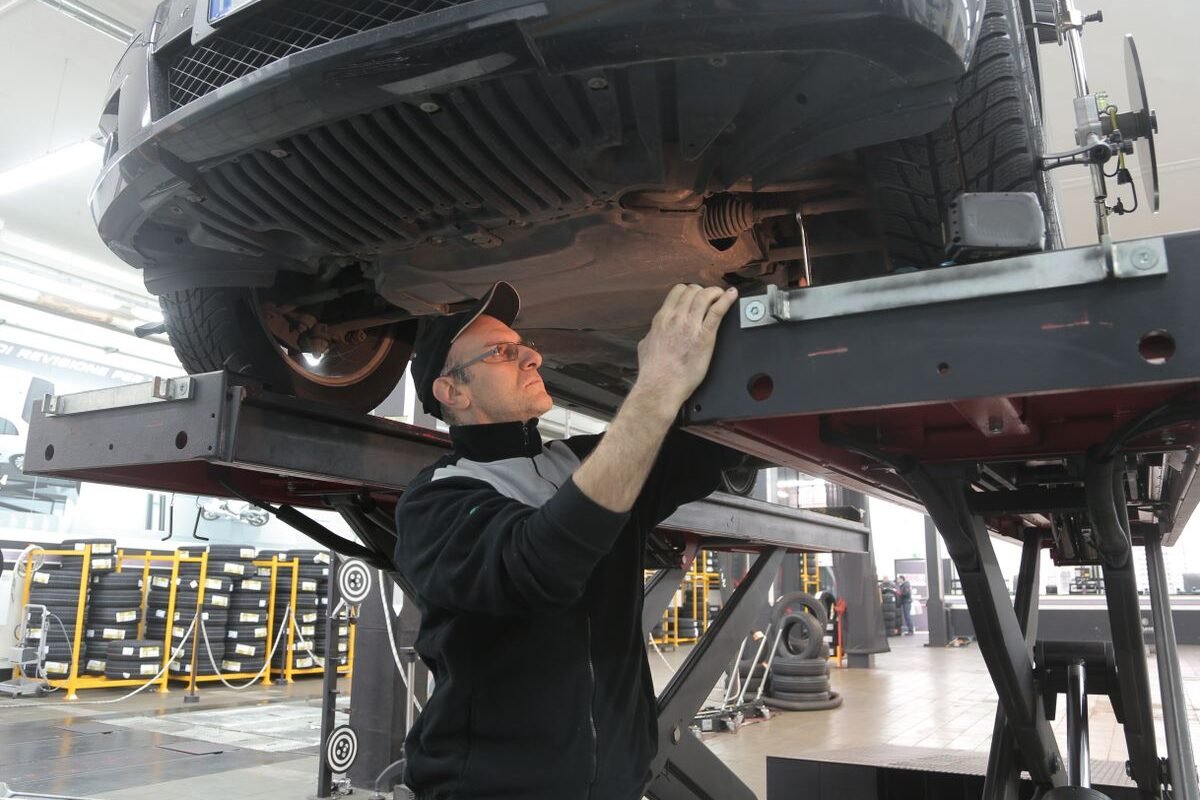 Mechanic inspecting a vehicle on a lift