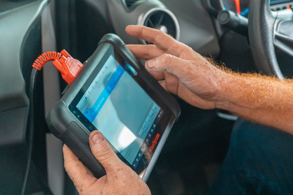 Mechanic using a diagnostic tablet inside a van