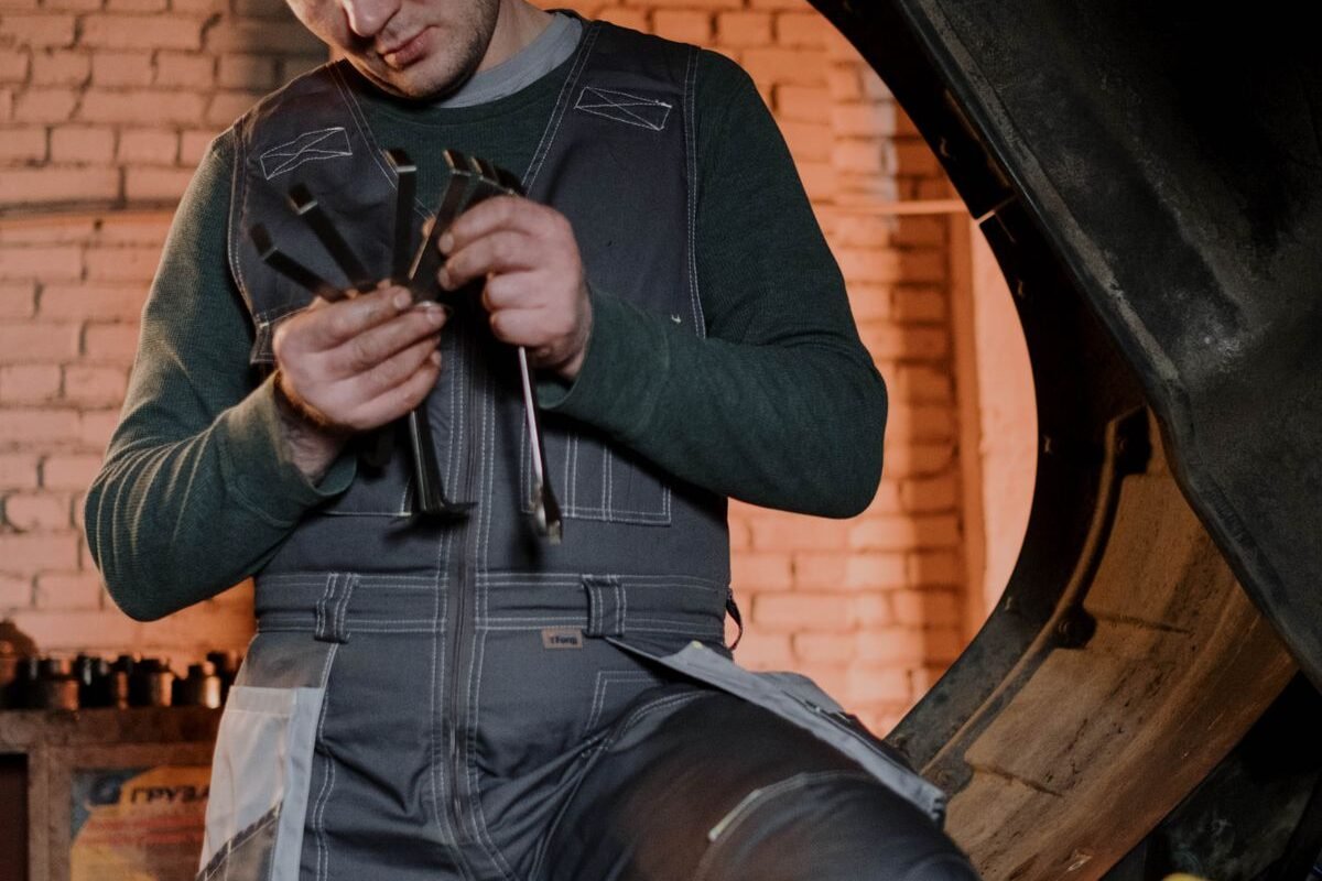 Mechanic tuning up diesel engine parts with precision tools