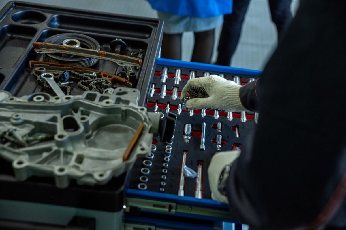 Mechanic organizing engine parts and tools in a workshop