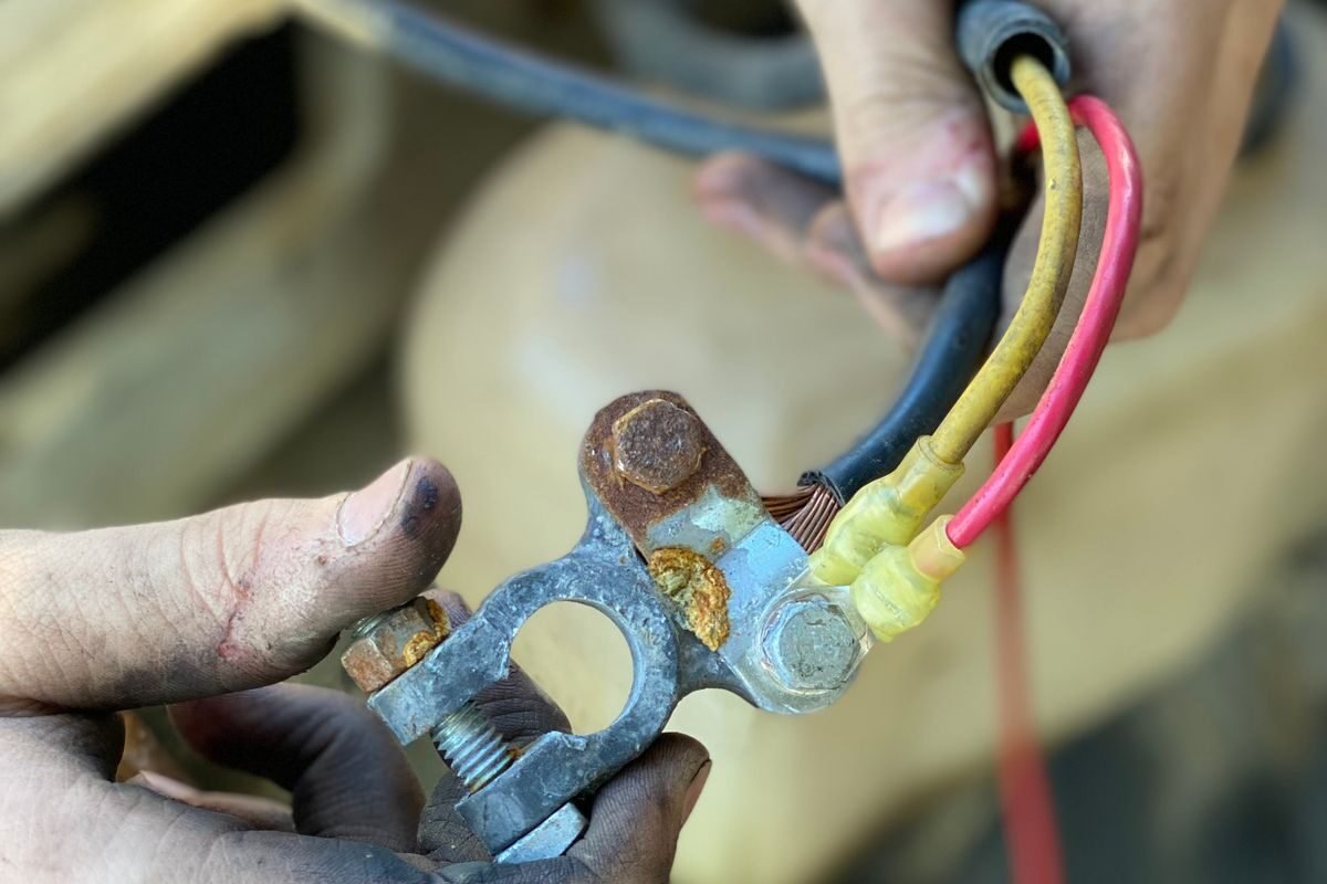Hands working on vehicle wiring during a repair
