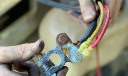 Hands working on vehicle wiring during a repair
