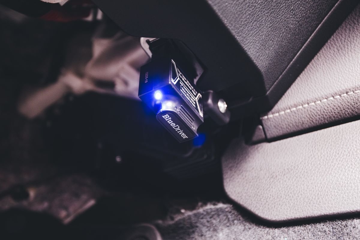 Bluetooth code reader diagnostic tool connected inside a vehicle