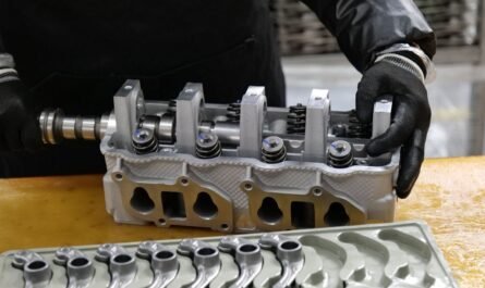 Mechanic assembling an engine cylinder head with precision components