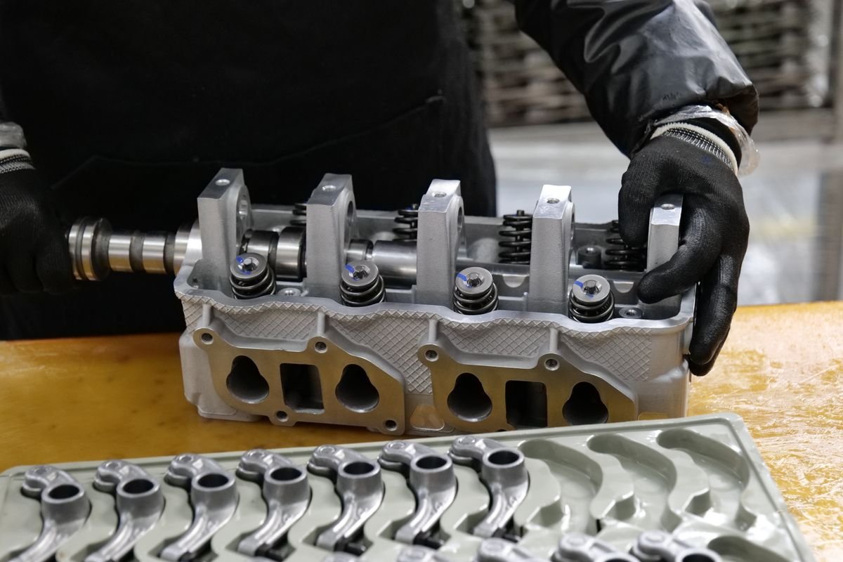 Mechanic assembling an engine cylinder head with precision components