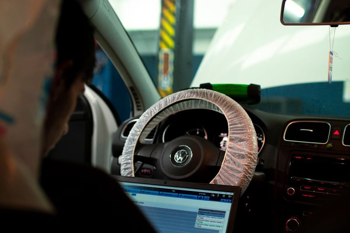 Mechanic using a laptop to diagnose a van fault