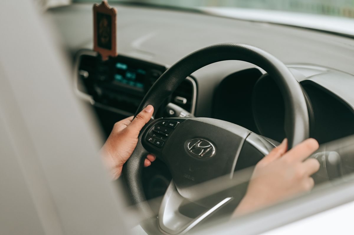 Hands holding the steering wheel inside a vehicle