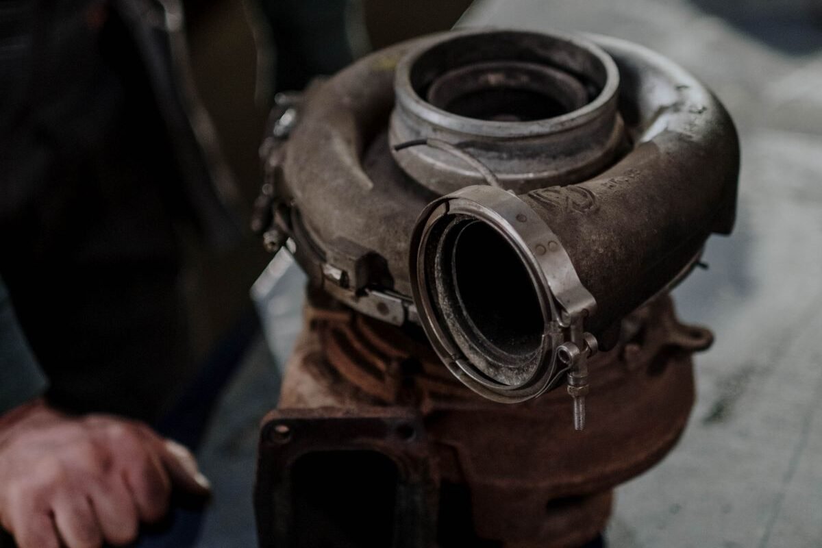 Worn turbocharger on a workbench in an auto repair shop